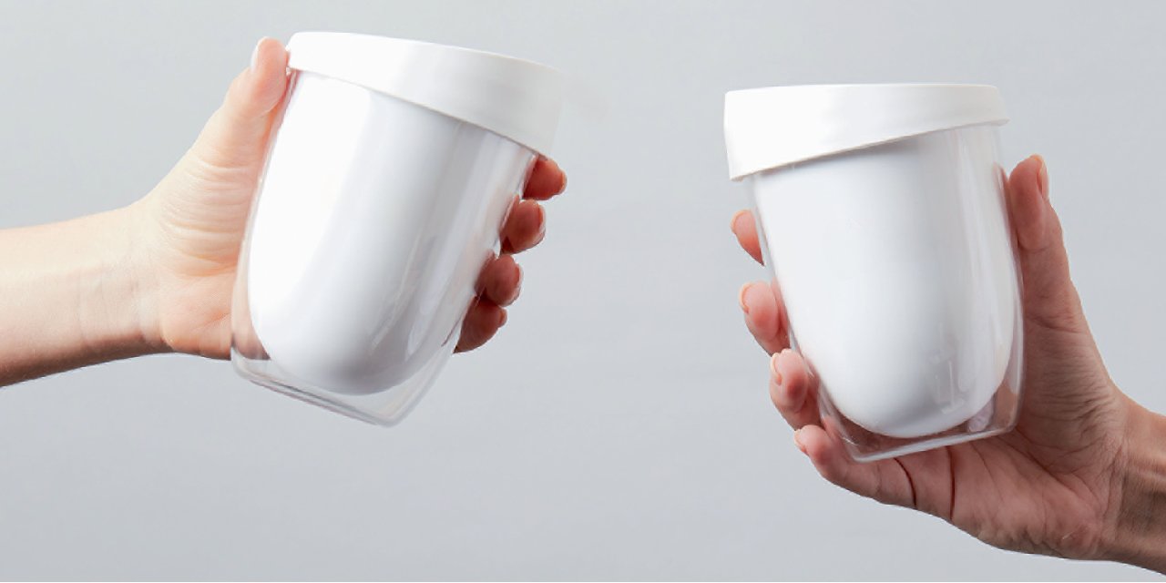 Two hands with white reusable uppercups 